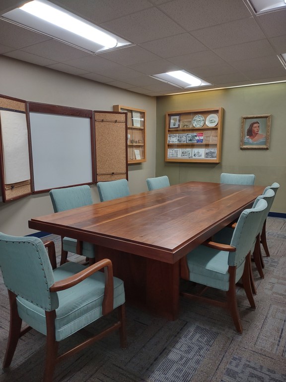 The library conference room includes a large table and seating for eight people.