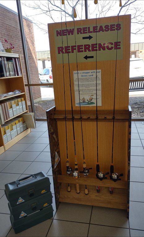 Fishing rods and tackle boxes are displayed on a stand.